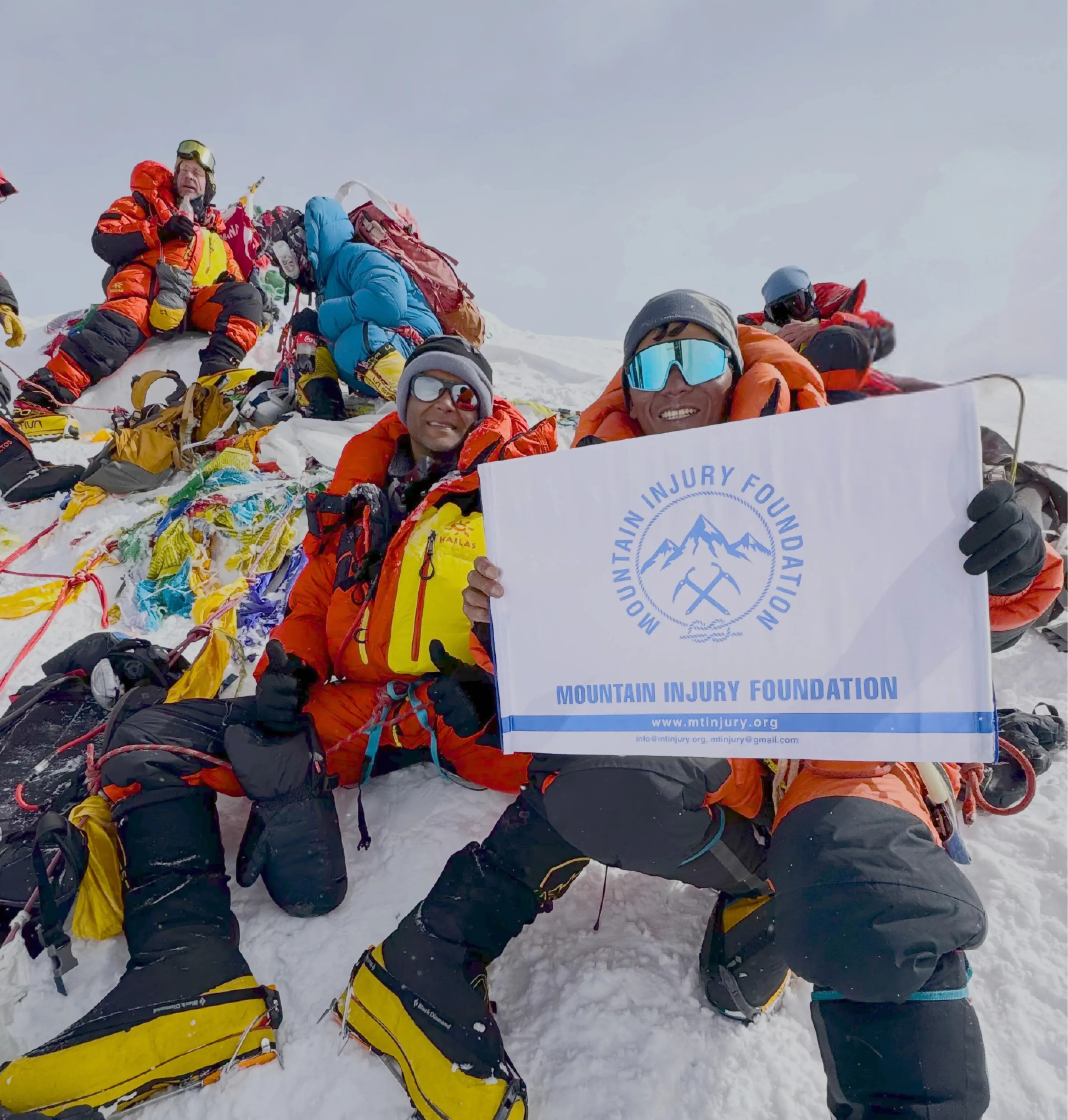 Mountaineers standing together at a snowy summit Mountaineers standing together at a snowy summit